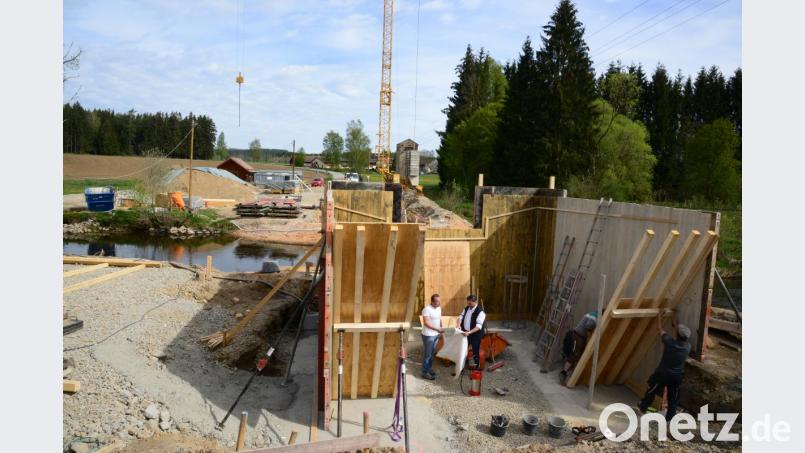 In den hölzernen Einschalungen entstehen die Widerlager für die neue Brücke über die Pfreimd. Bauamtsleiter Uli Rupprecht (links) und Bürgermeister Rainer Rewitzer machen sich ein Bild vom Fortschritt der Bauarbeiten, die voll im Zeitplan liegen. Bild: bey