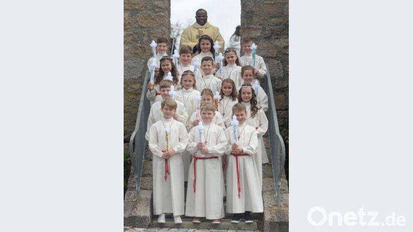 Kommunion in Freudenberg: Pfarrer Moses Gudapati mit den 16 Erstkommunionkindern. Bild: brü