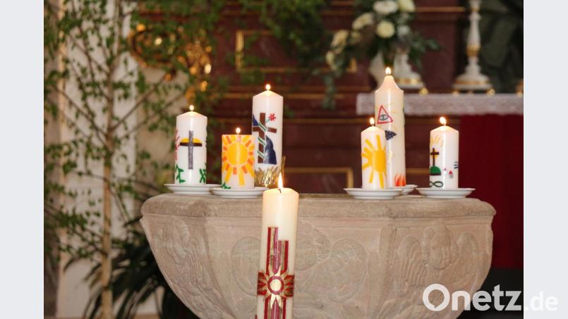 Jede Konfirmandin und jeder Konfirmand hatte eine Kerze mit christlichen Symbolen gestaltet, die auf dem historischen Taufstein standen. Bild: rpp