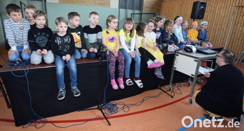 Die Erstklässler der Grundschule Illschwang führen auf der neuen Bühne das Chorprojekt des MuK auf. Dessen Leiter Gerald Ludwig (im Vordergrund, rechts) behält alles im Auge. Bild: no