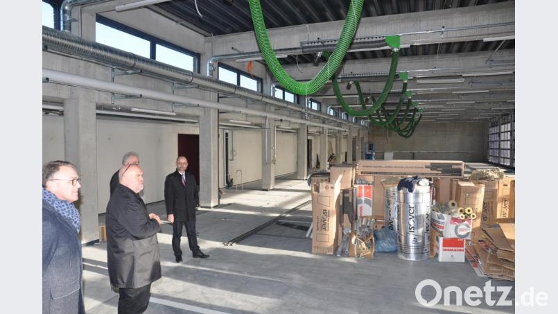 In der Fahrzeughalle im Feuerwehrhaus ist auch modernste Absaugtechnik für die Autos angebracht. Die Schläuche an der Decke werden an den Auspuffanlagen angedockt. Beim Verlassen der Halle &quot;fahren&quot; die Schläuche mit und werden dann automatisch am Tor abgekoppelt. Architekt Peter Brückner (Zweiter von links) erläuterte dem Stadtrat die Einrichtung. Bild: ws