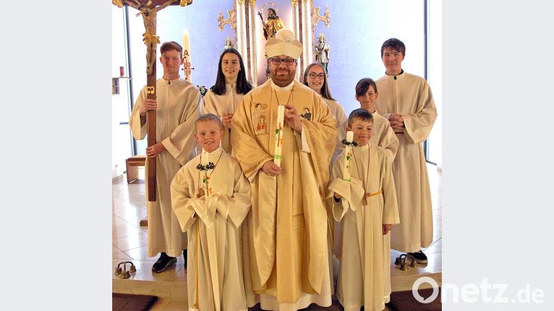 Die Ministranten und Pater Johannes feieren die Erstkommunion mit den beiden Komminionkindern. Bild: zer