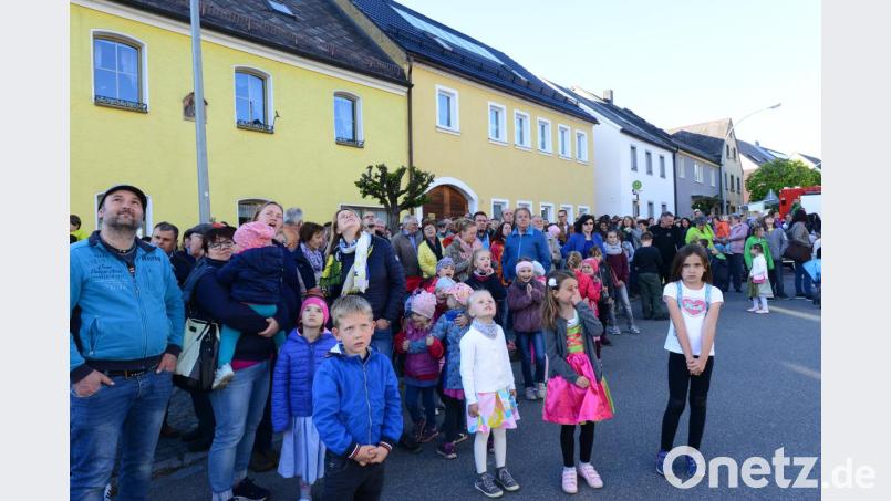 Gespannt verfolgen die Zuschauer, wie der Maibaum auf dem Neuhauser Marktplatz aufgerichtet wird. Bild: bey