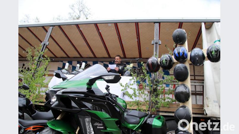 Mario schneider begrüßt die Gäste beim Motorradgottesdienst am Hüttener Festplatz, den ein neues Bikerkreuz ziert. Bild: jma