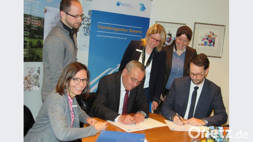 Oberbürgermeister Kurt Seggewiß (Mitte) und Florian Neumann, Leiter der Transferagentur Bayern, unterzeichnen die gemeinsame Zielvereinbarung zwischen Kommune und der Einrichtung der Metropolregion Nürnberg. Bild: exb
