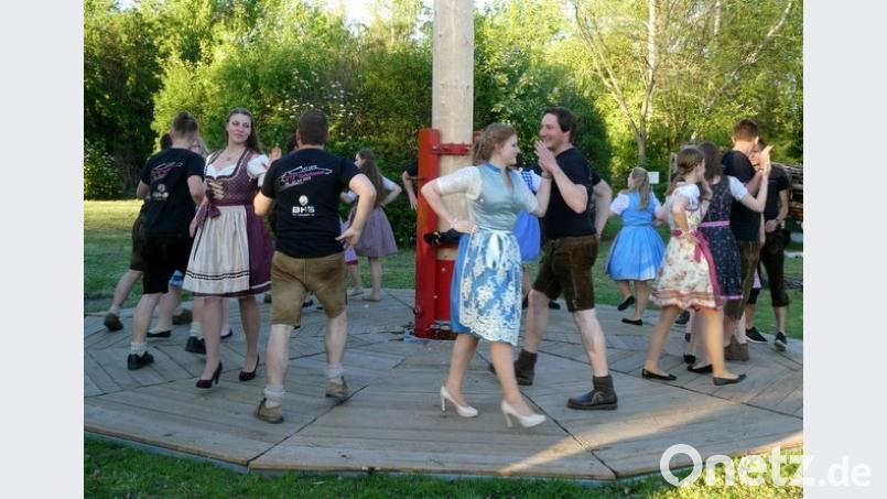 Die Festdamen tanzen mit ihren Partnern gekonnt um den Maibaum. Bild: bk