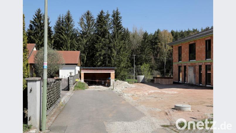 Was den Anschein einer optimalen Doppelgaragen-Einfahrt hat, stellt sich aus einem anderen Blickwinkel als die Überbauung eines seit Menschengedenken genutzten öffentlichen Feld- und Waldweges dar. Das blaue Ziffernschild mit der Nummer 25 an dem Laternenmast (links im Bild) weist noch darauf hin, dass hier auch einmal ein Wanderweg ausgewiesen war. Jetzt ist an einem gelben Betreten-verboten-Schild und rot-weißen Trassierband Schluss. Bild: Wolfgang Steinbacher