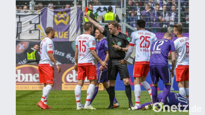 Die Schlüsselszene der Partie: Regensburgs Jann George (links) muss mit Gelb-Rot vom Platz. Binnen drei Minuten erachtet Schiedsrichter Pascal Müller (Vierter von links) zwei Vergehen des Jahn-Angreifers als gelbwürdig. Aus dem folgenden Freistoß kassiert der SSV auch noch das 0:1. Bild: agentur_dpa
