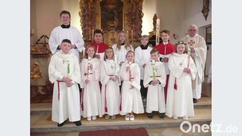 Die Kommunionkinder (vorne, von links) Valentin Scherr, Katharina Betz, Mia Griebl, Lena Linsmeier, Tim Laubmeier und Julia Mösbauer, zusammen mit Pfarrer Eugen Wismeth (rechts) und den Ministranten. Bild: amö