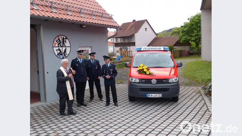 Pfarrer Arnold Pirner segnet die Garage und den Mannschaftstransportwagen der Neudorfer Wehr. Bild: hme
