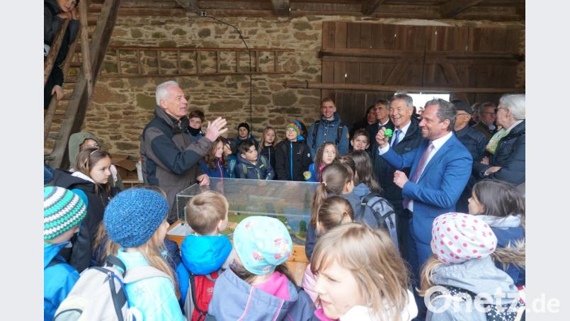 Da kann auch der Umweltminister (rechts) noch etwas lernen. Der stellvertretende Landrat Arnold Kimmerl (links) erklärt ihm und den Kindern, wie Frösche sicher über die Straße kommen. Bild: Christopher Dotzler