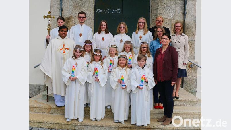 Acht Mädchen und Buben der Pfarrei traten am Sonntag in der Pfarrkirche „Maria Immaculata“ erstmals an den Tisch des Herrn. Bei einem feierlichen Festgottesdienst empfingen sie von Pater Martin ihre erste heilige Kommunion und wurden in die Mahlgemeinschaft mit Gott und der Gemeinde aufgenommen. Pater Martin wünschte den Kindern und ihren Familien auf ihren Lebensweg immer die Nähe zu Gott und das sie die Kirche als lebendige Gemeinschaft sowie als wichtigen und wohltuenden Ort erleben können. Für die tatkräftige Vorbereitung und Unterstützung zur diesjährigen Erstkommunion dankte der Priester am Ende des Gottesdienstes den Tischmüttern Carolin Breitner, Hannelore Janko und Claudia Paukner sowie den Eltern der Kommunionkinder. Für die besonders festlich geschmückte Pfarrkirche würdigte der Priester, Messner Tobias Megies. Mit einer musikalischen Glanzleistung umrahmte der Singkreis „Cantiamo“ unter der Leitung von Karin Gerolstein den Festgottesdienst. Nach dem Festgottesdienst stellten sich Pater Martin (mitte links), die Tischmütter Claudia Paukner, Carolin Breitner (hinten von rechts), Hannelore Janko (mitte rechts) sowie Schulleiterin Inge Dick (vorne rechts) mit den Ministranten (hinten) und den Kommunionkindern Pia-Marie Breitner, Anja Haubner, Elena Janko, Eva Kaßeckert, Sophie Paukner, Emilia Schmitt, Sarah Tretter und Ben Weiß zum Erinnerungsfoto. Bild: bsc