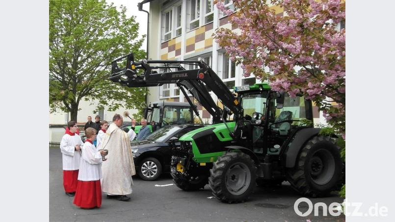 Pfarrer Heribert Stretz segnet neben Auto und Fahrräder diesmal auch zwei Traktoren. Bild: hl