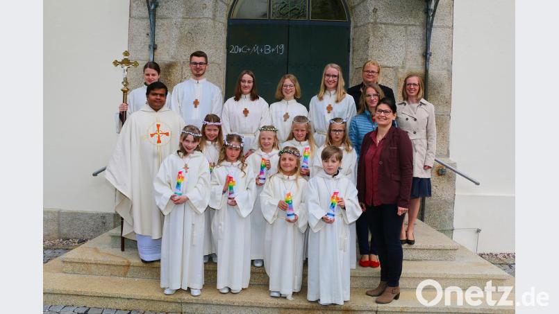 Nach dem Festgottesdienst stellten sich Pater Martin (Mitte links), die Tischmütter Claudia Paukner, Carolin Breitner (hinten von rechts), Hannelore Janko (mitte rechts) sowie Schulleiterin Inge Dick (vorne rechts) mit den Ministranten (hinten) und den Kommunionkindern Pia-Marie Breitner, Anja Haubner, Elena Janko, Eva Kaßeckert, Sophie Paukner, Emilia Schmitt, Sarah Tretter und Ben Weiß zum Erinnerungsfoto. Bild: bsc