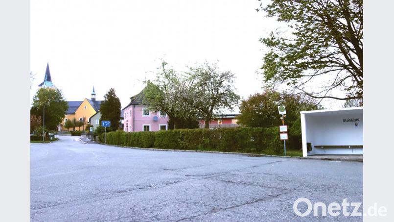 Ein großes Stück der Hecke soll weg, damit neun neue Parkplätze zwischen dem Buswartehäuschen (rechts) und dem Benefiziatenhaus (links) entstehen können. Bild: fjo