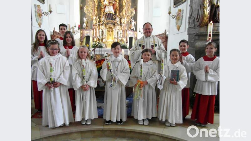 Die Erstkommunion der Waldecker Kinder steht unter dem Motto „Unter Gottes Regenbogen“. Von Pfarrer Heribert Stretz (hinten links) empfangen sie im Festgottesdienst erstmals den Leib Christi. Bild: hl