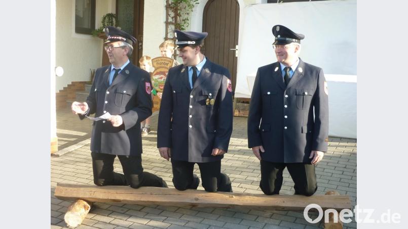 Zum Vortrag ihrer formalen Bitte an die Festmutter musste sich die Feuerwehrführung auf ein Vierkantholz knien. Im Bild von links Peter Böckl, Albert Haas und Alfons Schmitzer jun. Bild: haa