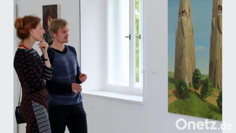 Marten Schädlich (rechts), einer der fünf Meisterschüler der Hochschule für Grafik und Buchkunst in Leipzig, spricht mit einer Besucherin über sein Werk „Einzelwir“. Bild: Thomas Dobler