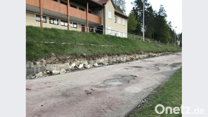 Während der Gemeinderat die Gewerke für die Sportplatzsanierung vergibt, brechen die Mitglieder des Sportvereins in Eigenarbeit die Mauer an der Laufbahn ab. Bild: eig