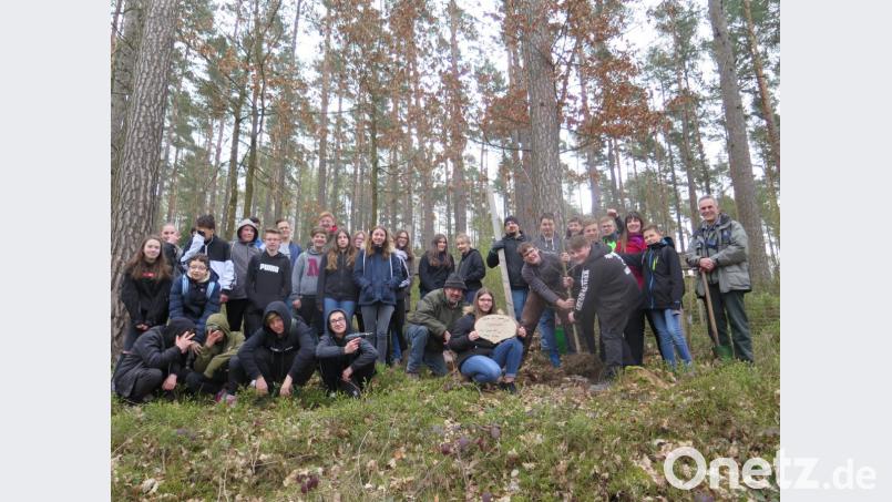 Forstdirektor Dirk Lüder (rechts) lobt die Achtklässler bei ihrer Pflanzaktion im Schulwald im Herrenhölzl. Bild: jzk
