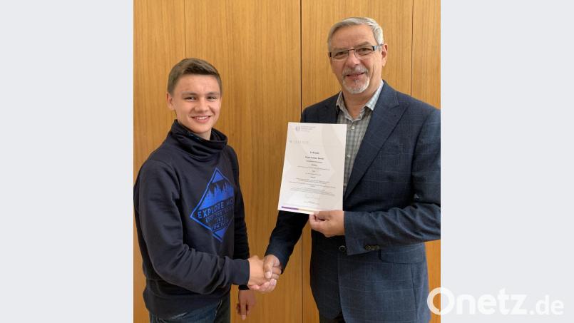 Schulleiter Karl Bösl (rechts) gratuliert dem Gewinner Noah Bauch, Klasse 9b, und überreicht die Urkunde. Bild: Irene Grünauer /exb