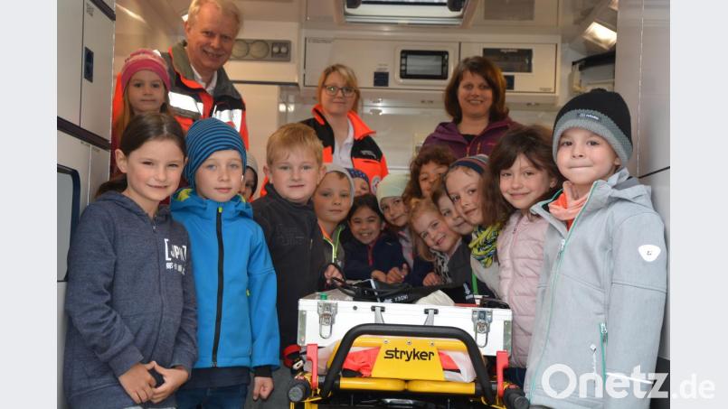 Bereitschaftsleiter Hugo Hofmann und Rettungsassistentin Corinna Reuß (Mitte) zeigten den Vorschulkindern das Innenleben eines BRK-Rettungswagens. Mit dabei Kinderhausleiterin Imke Steinert. Wichtig war den BRK-Verantwortlichen, die Notrufnummer 112, damit diese verinnerlicht wird. Bild: jr