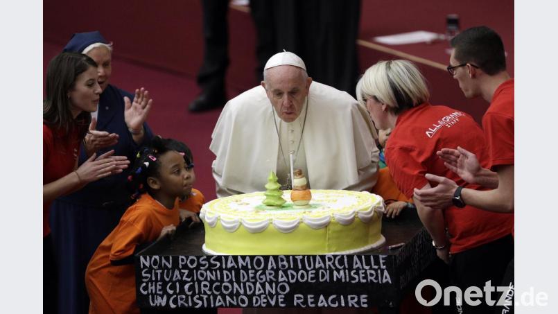 Ein Beispiel für ein gelungenes Foto, auf dem zwar mehrere Menschen zu sehen sind, der Papst aber dennoch sofort als die im Mittelpunkt stehende Person zu erkennen ist: Am Abend vor seinem 82. Geburtstag pustet Franziskus im Vatikan eine Kerze auf einer Torte aus. Archivbild: Gregorio Borgia/AP/dpa