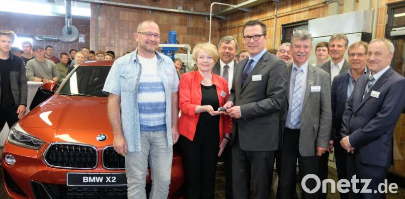 Im Beisein von Schülern und Ehrengästen übergab Andreas Sauer, BMW-Werksleitung (vorne, Dritter von links), den Schlüssel für das Fahrzeug an Schulleiterin Rosina Pimmer und Werkstattleiter Stefan Birner (vorne, links). Bild: ohr