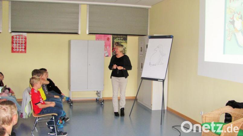 Autorin Ute Krause zeichnet den Pinguin auf, den die Schüler später ausmalen dürfen. Bild: sei