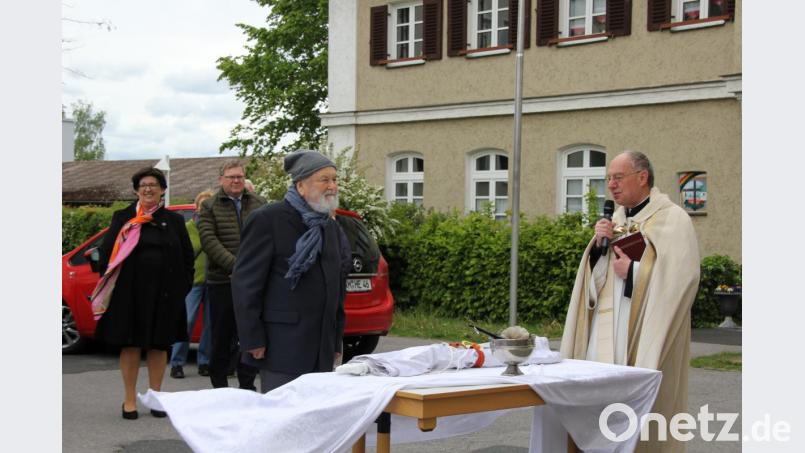 Im Beisein des Zeitzeugen Wolfgang Babl (mit Mütze) segnete Pfarrer Ludwig Gradl (rechts) das weiße Banner als Friedenssymbol. Bild: ads
