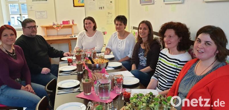Tanja Franz (an der Stirnseite sitzend) überzeugt die Kursteilnehmer um Mittendrin-Leiterin Jessika Wöhrl-Neuber (links) beim veganen Kochabend von ihren Rezepten. Bild: jzk