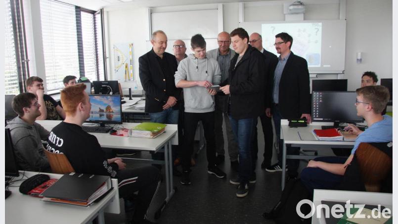 Die Schüler Michael Kraus und Giuseppe Mandolfo (von links, vorne in der Mitte) erklären den Pädagogen am Beruflichen Schulzentrum, Wolfgang Eckstein, Hartmut Seidler, Hermann Körner, Wolfgang Hecht und Martin Zithier, die einzelnen Funktionen am neuen Tablet-PC. Bild: wro
