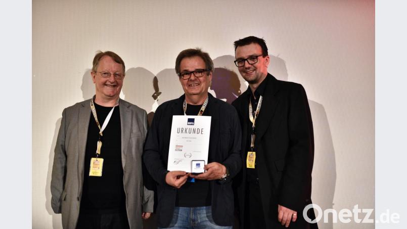 Der Juryleiter und Präsident des Landesverbandes Film und Video Bayern, Adalbert Becker (links), und Festivalleiter und Präsident des Bundesverbandes Deutscher Filmautoren, Marcus Siebler (rechts) gratulieren den Leiter der AG Video, Egid Spies. Bild: Katharina Huber
