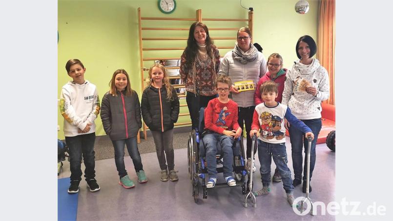 Schnell noch ein Foto von der Spendenübergabe an Sabine Arbter (rechts) und dann ab zum Spielen: Nachdem die Waldecker Kommunionkinder (links) mit den Müttern Melanie Kastner und Lisa Schiml (hinten von rechts) das Geld überreicht hatten, verbrachten sie die Zeit mit ihren Altersgenossen von der Petö-Tagesstätte. Bild: hl