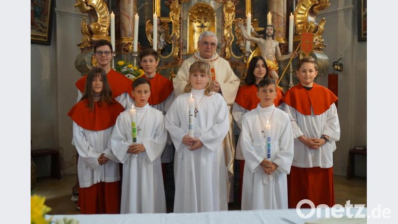 Die Erstkommunionkinder Mona Krämer, Bastian Simbeck und Timo Simbeck, zusammen mit Pfarrer Eugen Wismeth und den Thansteiner Ministranten. Bild: rkp