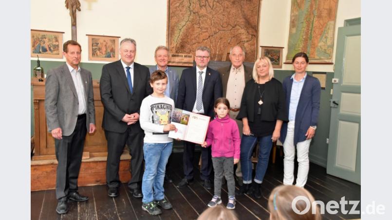 Simon Drexler und Luisa Kraus (vorne) von der Grundschule aus Neunburg vorm Wald nahmen bei ihrem Besuch am Mittwoch die Urkunde für den 250 000. Besucher im Schulmuseum entgegen. Mit ihnen freuten sich (von links)Museumsleiter Herbert Übelacker, Landrat Richard Reisinger, Sparkassen-Gebietsdirektor Alois Auer, Bürgermeister Michael Göth, Klaus Kreil (Förderverein), Martina Herbst und Martina Windisch-Keck (Museum). Bild: Andreas Royer