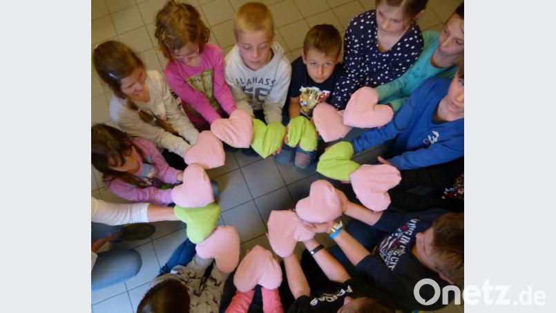 Stolz präsentieren die Kinder ihre Wärmekissen in Herzform, die sie für den Muttertag gebastelt hatten. Bild: bgl