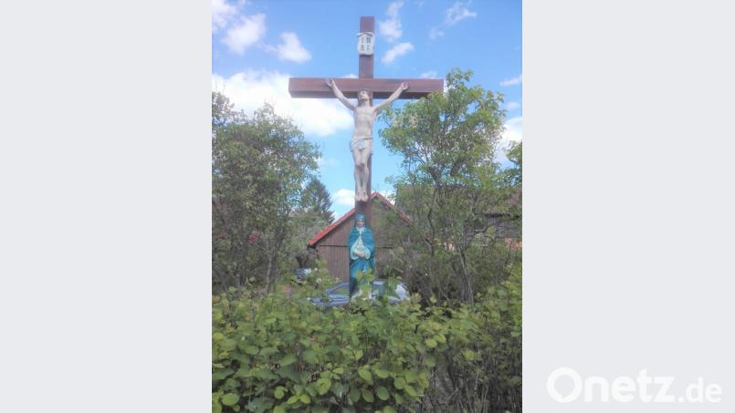 Kirchenmalerin Monika Müllner hat das Holzkreuz restauriert. Nun steht es wieder an in neuem Glanz an seinem angestammten Platz in der Neuenhammerstraße 24. Bild: tu