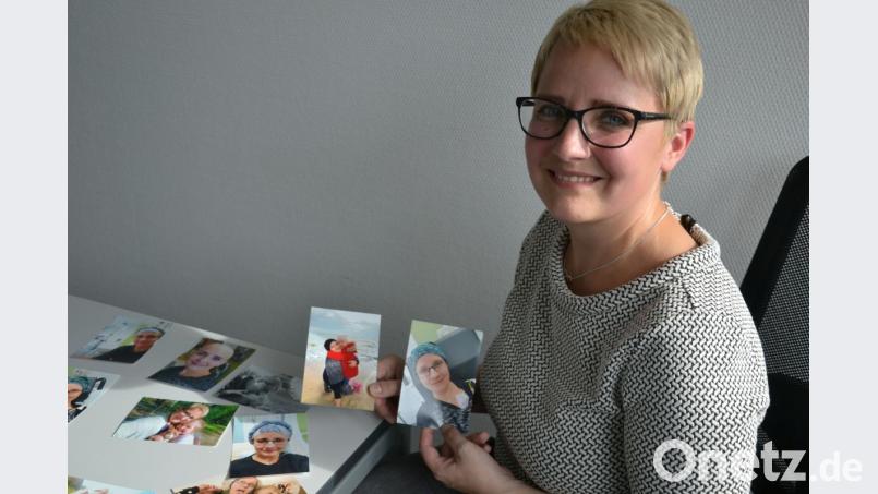 Anita Schiller (35) zeigt von Fotos von sich mit Kopftuch, mit Glatze und von der Zeit auf Reha, die sie mit Tochter Klara (5) an der Ostsee verbrachte. Bild: Lowak