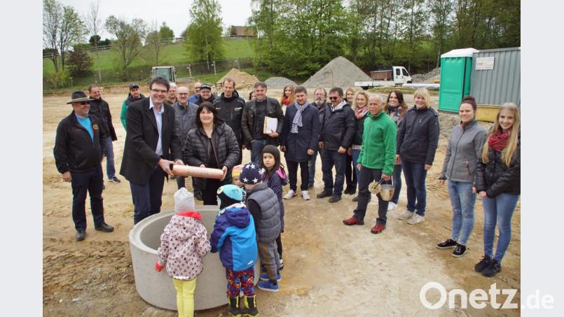 Pfarrer Wolfgang Dietz und Bürgermeisterin Birgit Höcherl mit der &quot;Zeitkapsel&quot;, die im Fundament des neuen Kindergartens einen Platz für immer bekommt. Am Bau beteiligte Personen und Firmen verfolgten die Grundsteinlegung. Bild: mmj