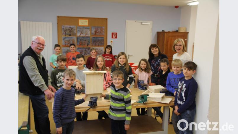 Der Vorsitzende des OWV Oberviechtach, Günther Flierl (links) baute mit den Niedermuracher Grundschülern nach dem Muster im Vordergrund Fledermaus-Häuschen und erzählte ihnen einiges über diese Tierart. Bild: frd