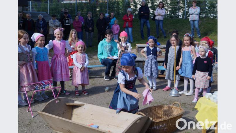 Die Waschfrauen zeigen beim Maifest des Kindergartens einen originellen Auftritt. Dabei kommen sogar Waschtrog und Stampfer wie in früheren Zeiten zum Einsatz. Bild: du