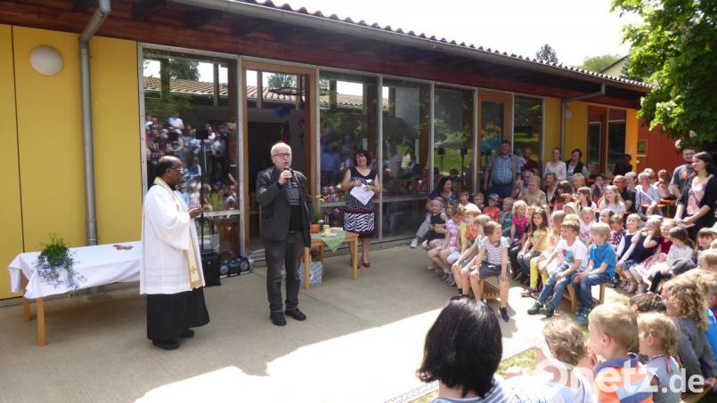 Pfarrer Gudapati, Pfarrvikar Robert Kratzer, Kindergartenleiterin Ulrike Schießlbauer (von links) und natürlich die Mädchen und Buben, die in St. Walburga betreut werden, freuen sich über den 20. Geburtstag des Kindergartens. Bild: jow