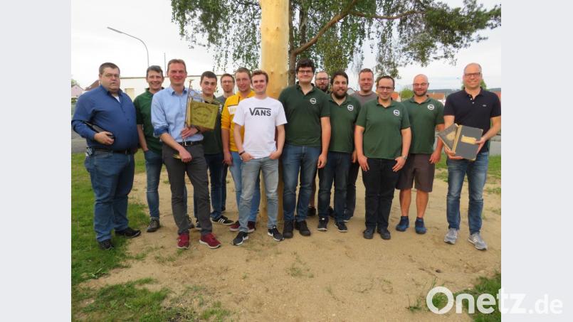 Bürgermeister Ernst Schicketanz (Dritter von links, mit Standarte) gratuliert Stefan Glowatzki (Achter von links) und seinem Vorstand zur Wiederwahl. Glowatzki dankt Markus Schneider und Andreas Greiner (von links) für ihre Treue. Bernhard Pscheidt (rechts) übergibt alte Kladden mit Protokollen. Bild: adj