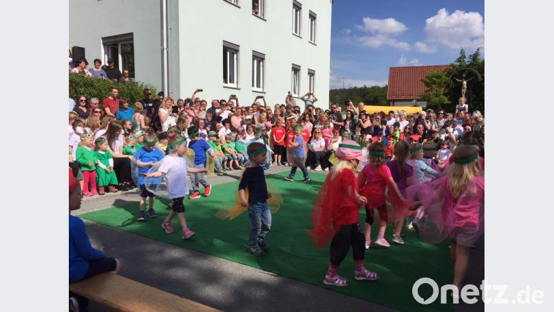 Bunte Tücher und lachende Gesichter prägen das Bild beim Kindergartenfest. Bild: krb