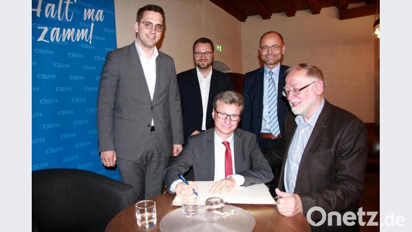 Vor der Podiumsdiskussion trug sich Staatsminister Bernd Sibler (Mitte) ins Goldene Buch der Marktgemeinde Falkenberg ein. Im Bild (stehend von links): Christian Doleschal, CSU-Ortsvorsitzender Matthias Grundler, stellvertretender Landrat Alfred Scheidler und Bürgermeister Herbert Bauer aus Falkenberg. Bild: wro