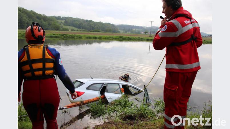 Mit Seilen wurde der weiße Kia fixiert, damit er nicht noch weiter die Naab hinabgetrieben wird. Die Stelle, an der das Auto in den Fluss fuhr, und die Stelle, an der der Fahrer gerettet wird (Bild), liegen 100 Meter auseinander. Ein Taucher sucht hier gerade die Umgebung des Wagens ab. Bild: Thomas Dobler