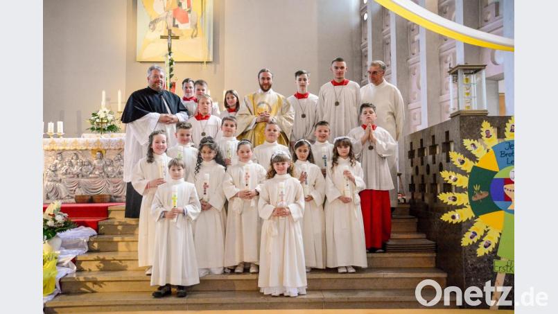Die Erstkommunionkinder der Pfarrei Hl. Familie mit Kaplan Florian Weindler (Mitte), Diplom-Religionspädagoge Carsten-Armin Jakimowicz (links) und dem liturgischen Dienst. Bild: Claudia Seitz/exb