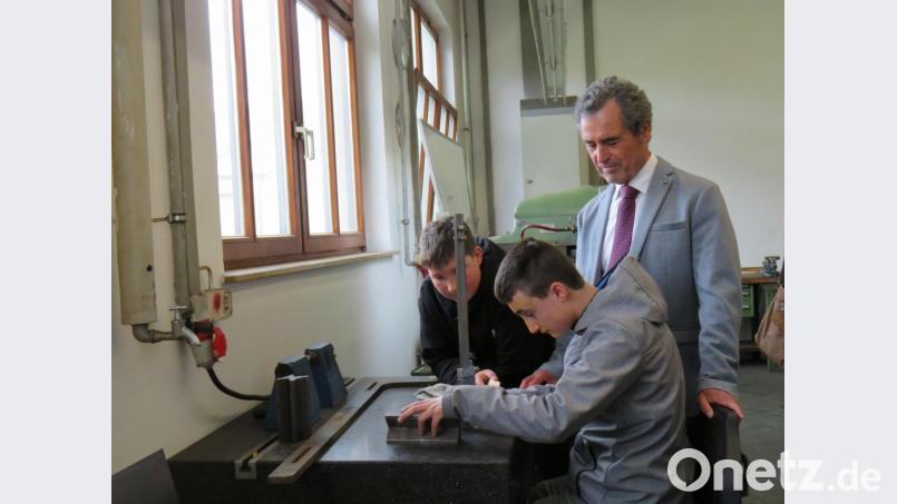 Schulamtsdirektor Rudolf Kunz schaut Max und Felix (von links) bei Metallarbeiten zu. Bild: ubb
