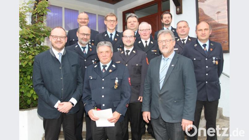 Mit der Verleihung des Feuerwehr-Ehrenzeichens in Gold würdigt Landrat Andreas Meier (links) die 40-jährige aktive Dienstzeit von Christoph Striegl (vorne, Mitte). Bild: pi